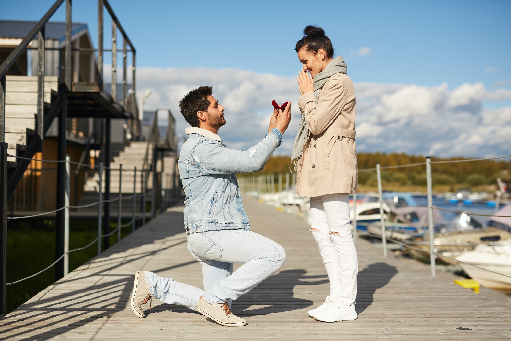 Man in love proposing to girlfriend on pier