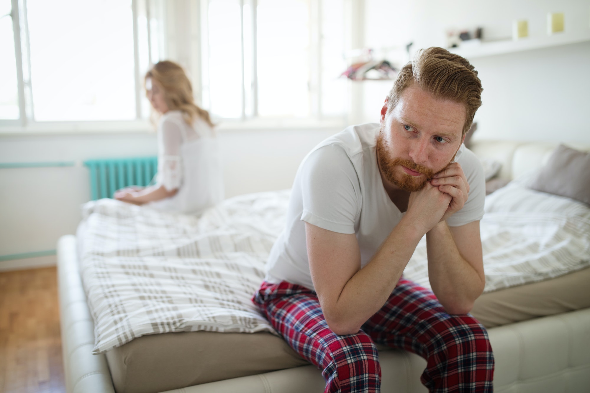 how to repair a marriage concept. couple sitting opposite sides of their bed